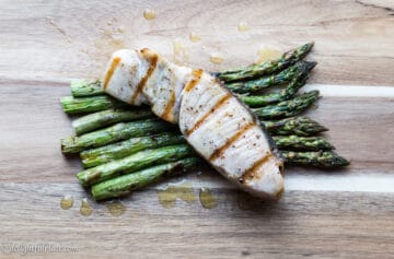 Grilled opah with asparagus on a serving board