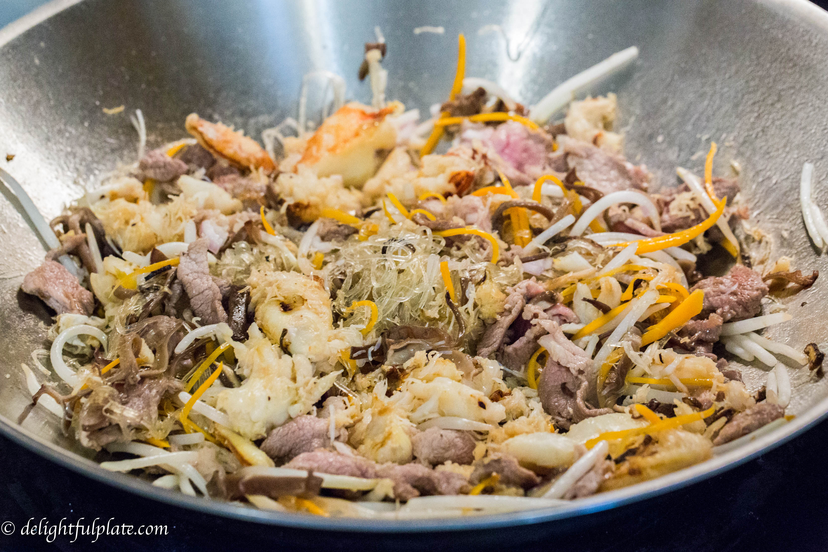 cooking Crab Cellophane Noodles, a traditional Vietnamese dish in a stir-fry pan