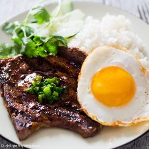 Vietnamese grilled lemongrass pork chops served with a fried egg and rice.