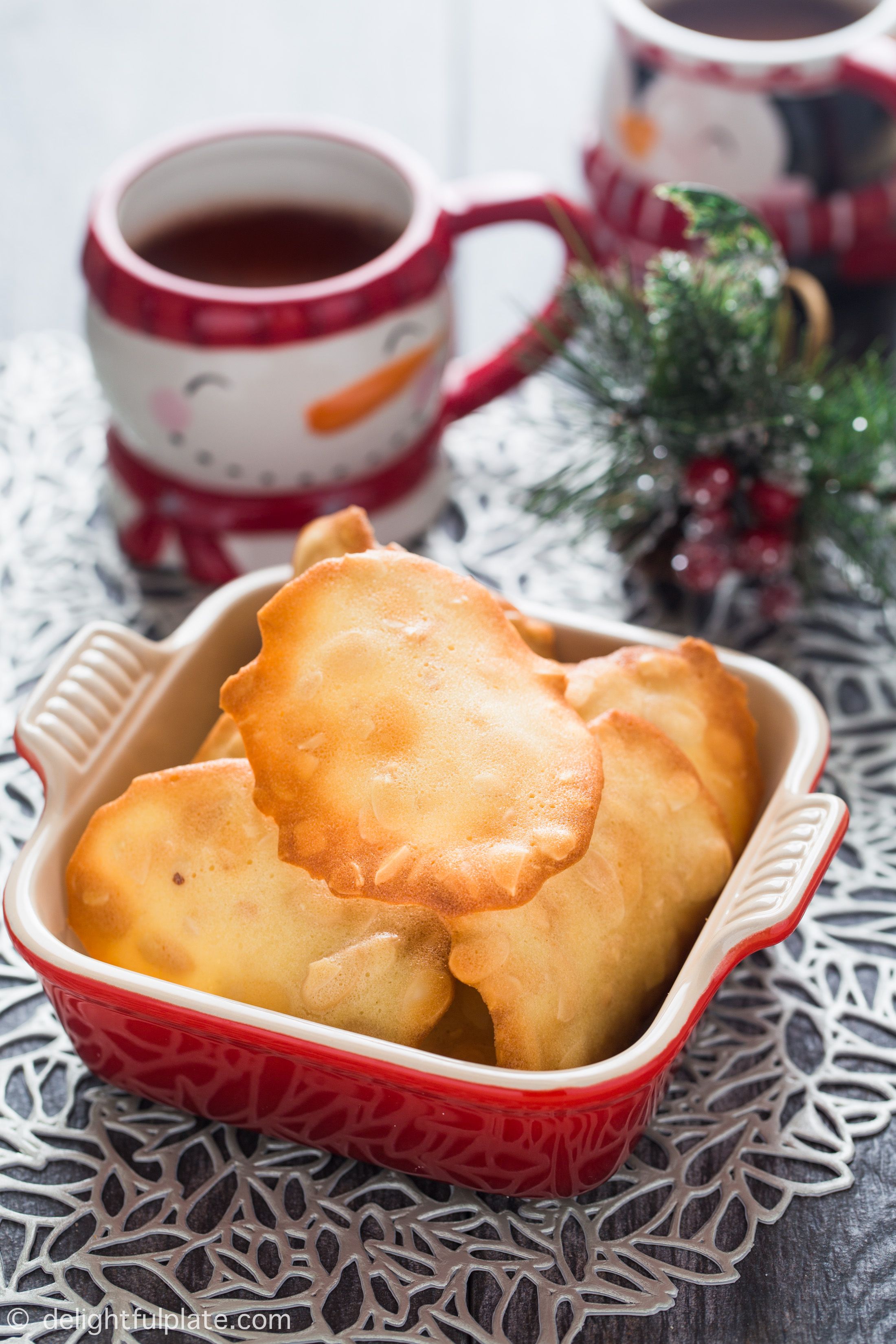 a plate of almond tuiles with holiday themed decorations