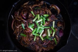 Add soy sauce mixture, butter, garlic and scallions to finish cooking Vietnamese shaking beef (Bo Lac Lac)