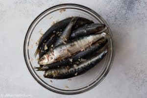 Sardines are marinated with shallots, garlic, salt and pepper before cooking.