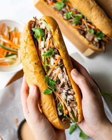 This Vietnamese Pulled Pork Banh Mi features crispy bread, tender and flavorful pork, crunchy pickled vegetables and yummy sriracha mayo sauce. With the help of a slow cooker, this banh mi sandwich recipe is super easy to make.
