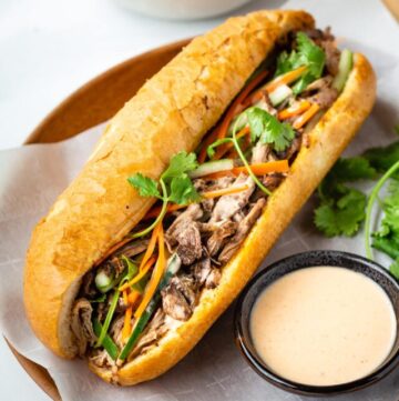 This pulled pork banh mi features Vietnamese baguette (banh mi) filled with tender and flavorful pulled pork, pickled vegetables, and tasty sriracha mayo sauce. With a slow cooker to cook the pulled pork, this delicious banh mi recipe cannot be easier to make.