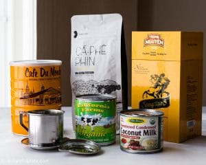 Ingredients and tools to make Vietnamese coffee (cafe sua nong): phin filter, ground coffee and sweetened condensed milk.