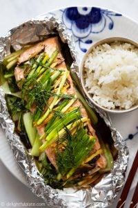 This Asian Ginger Salmon in Foil Packets is a healthy and delicious meal packed with juicy salmon, baby bok choy and herbs. Serve with steamed rice for a quick and easy weeknight dinner.