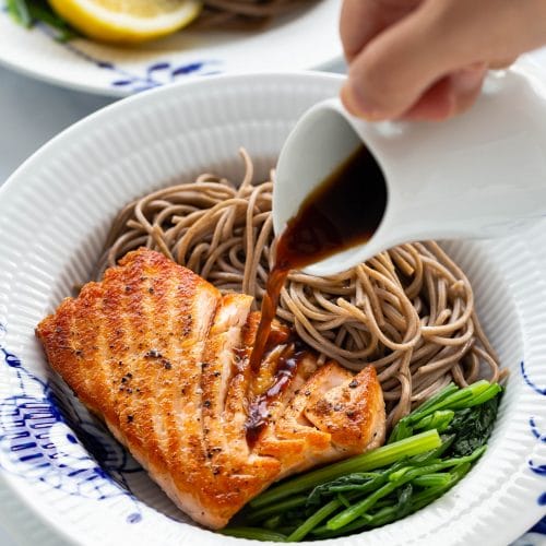 a plate of pan-seared salmon with soba noodle and green veggies