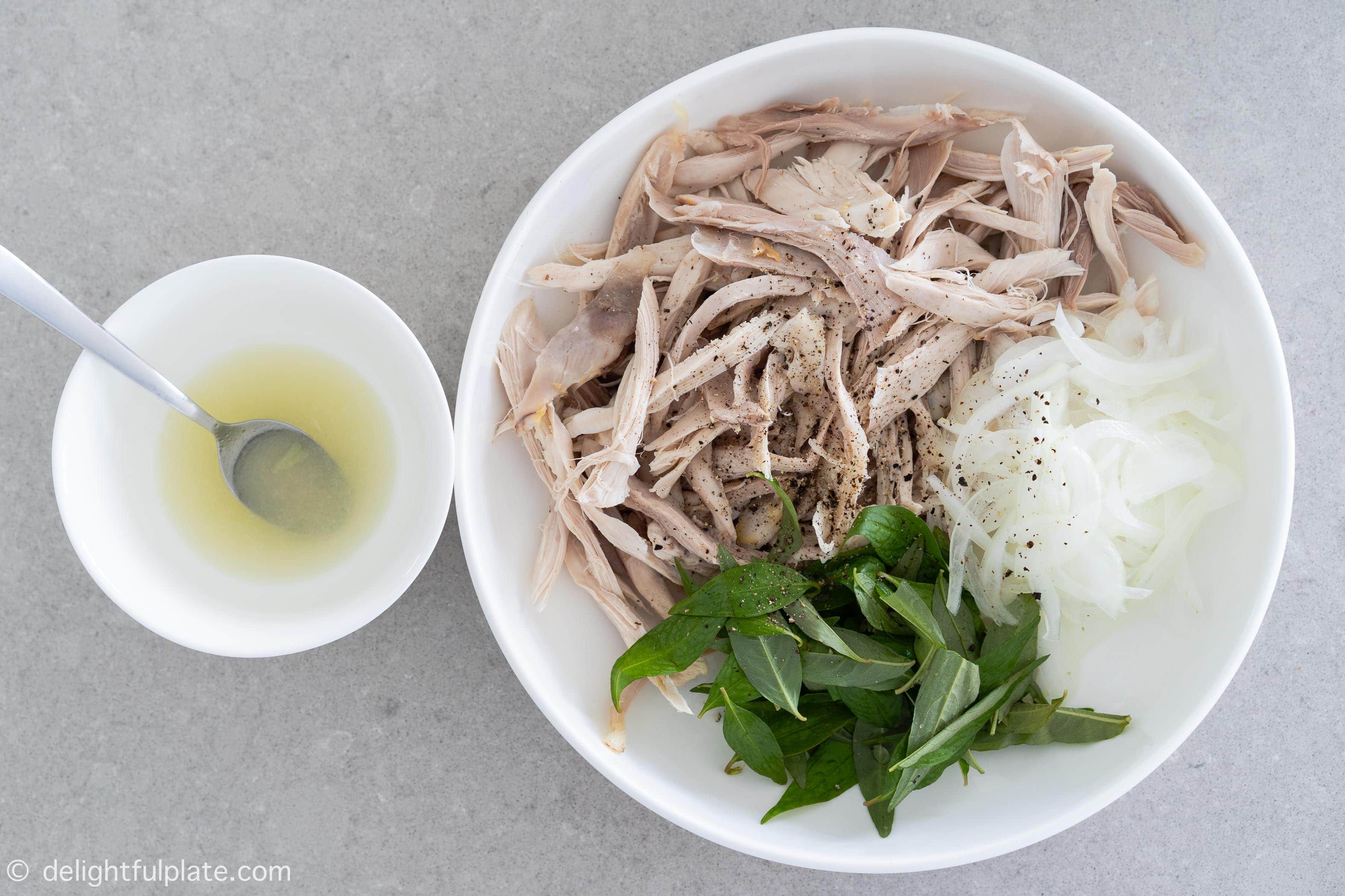 a plate with shredded chicken, onion and Vietnamese coriander