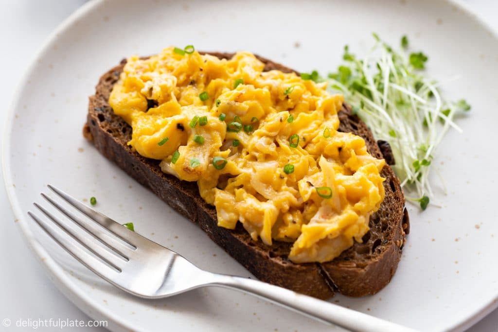 Soft and fluffy crab scrambled eggs on a slice of whole wheat bread. Serve it with a glass of smoothie or milk on the side for an absolutely healthy, delicious and filling breakfast.