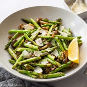 a plate of stir fried asparagus with mushrooms