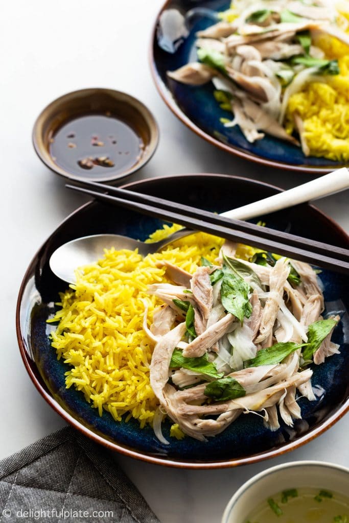 Com Ga Hoi An (Vietnamese Chicken Rice) features shredded chicken tossed with Vietnamese coriander, onions, and lime juice dressing. The chicken salad is then served with turmeric rice cooked directly in chicken stock.