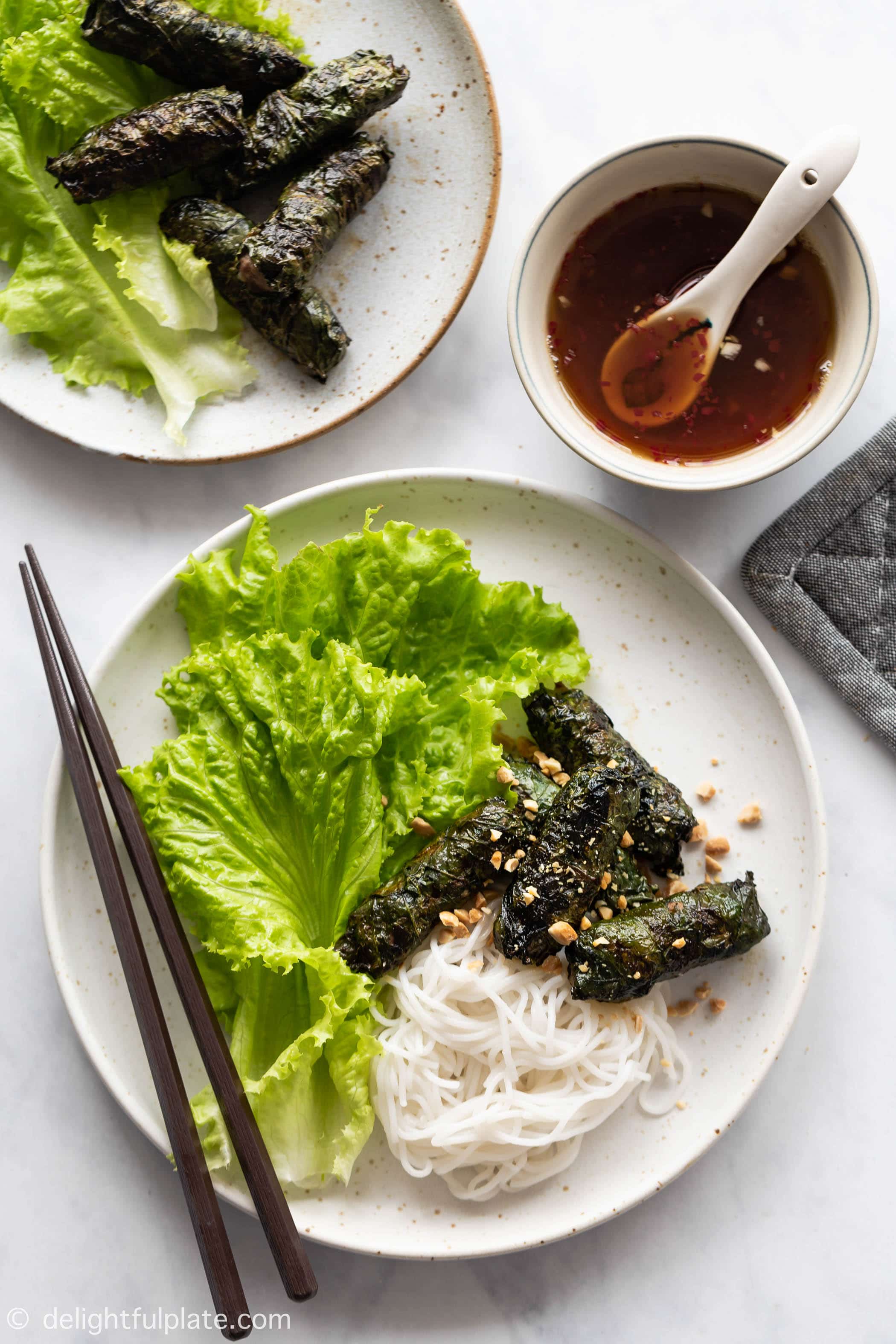 plates of Vietnamese grilled beef in betel leaves served with vermicelli noodles.