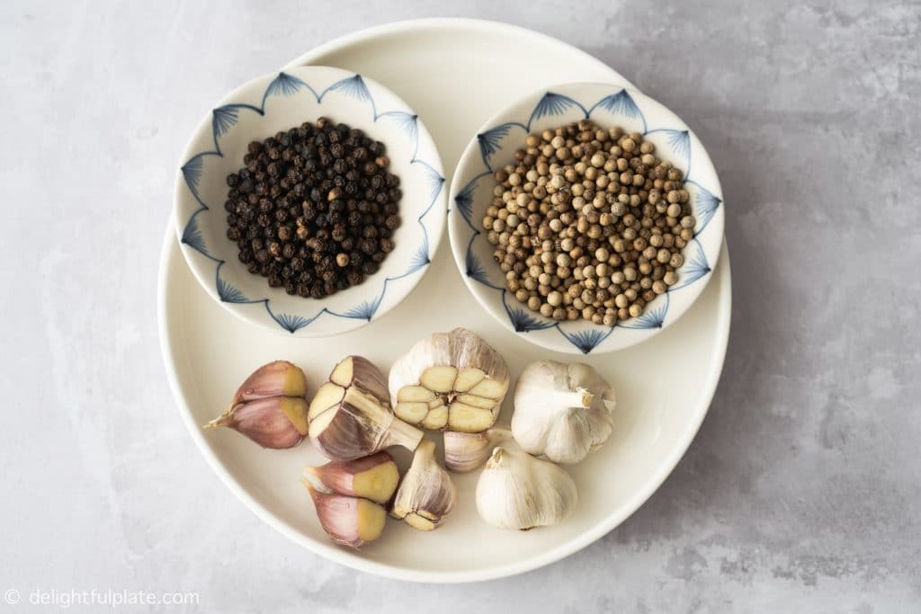 ingredients for bak kut teh: white peppercorns and garlic bulbs
