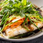 a steamed fish fillet with soy sauce, ginger, scallion, onion and carrot