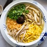 a bowl of Bun Thang Hanoi with shredded chicken, egg strips, shrimp floss, ham and scallions