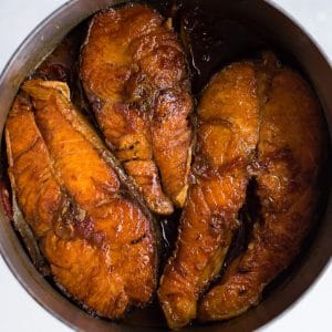 three pieces of caramelized salmon in a pot