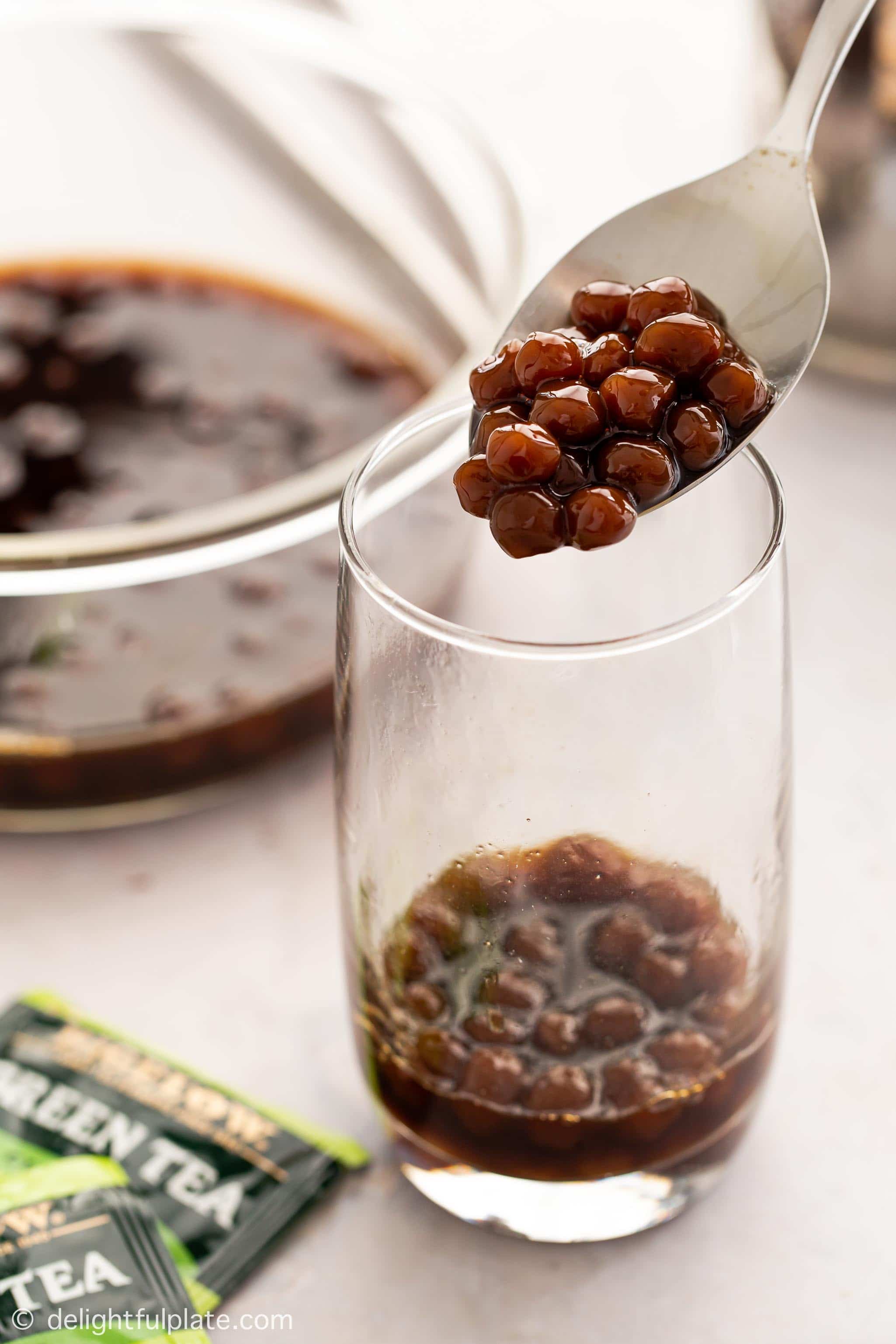 a spoon with black boba pearls