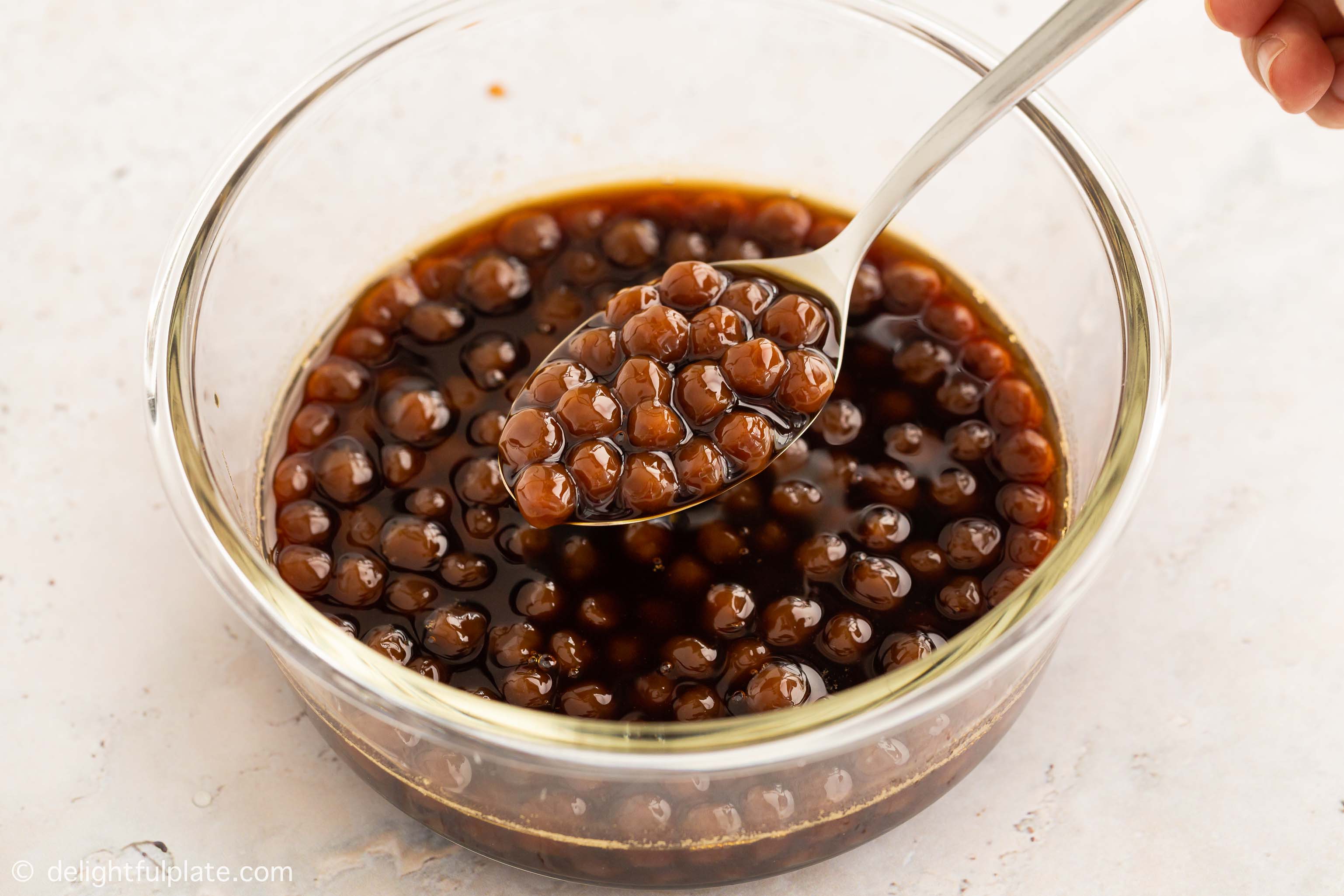 A container with black boba pearls in simple brown sugar syrup