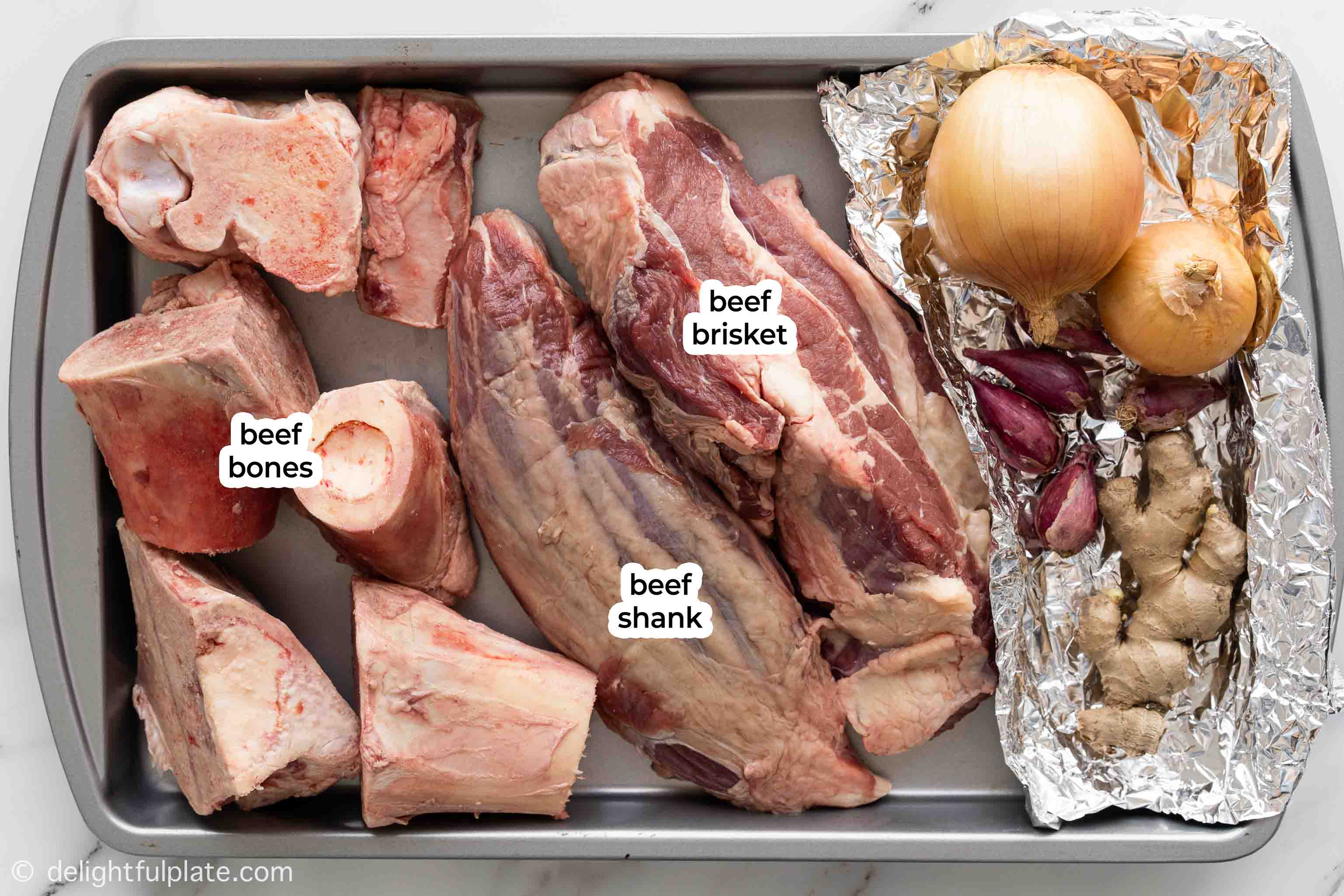 a tray with beef bones, brisket and shank to make pho broth