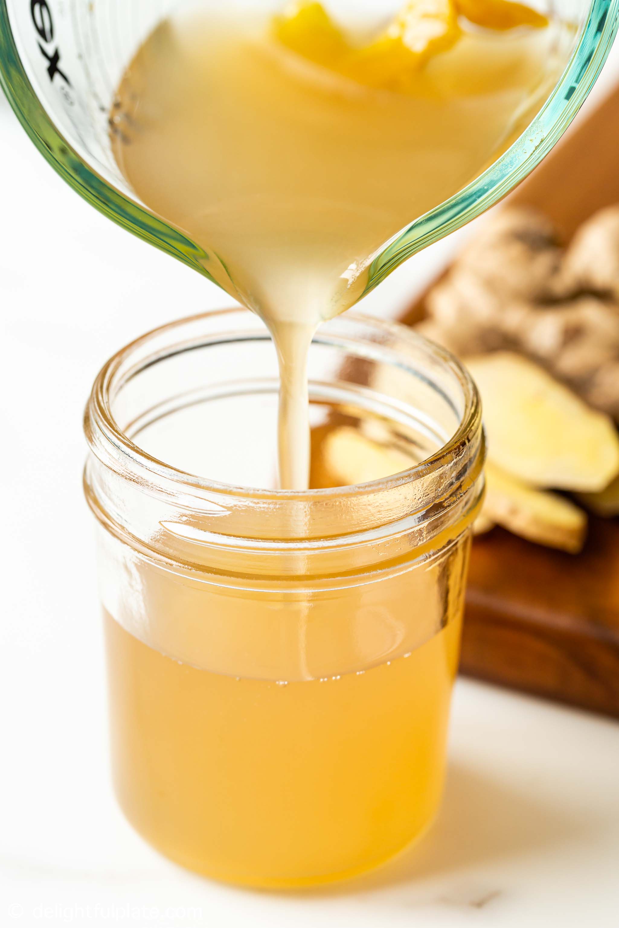 pouring ginger syrup into a jar