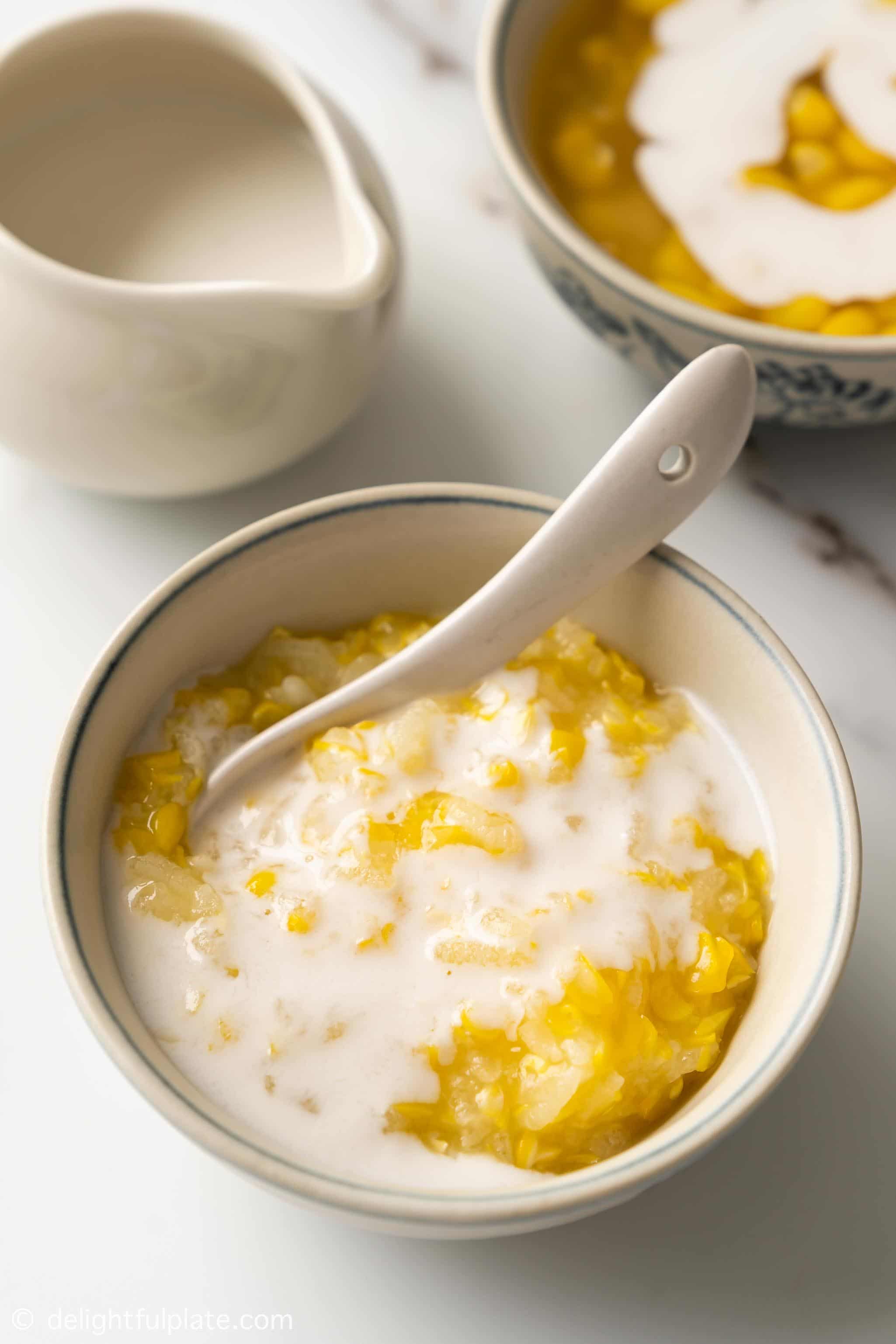 a bowl containing sweet corn pudding with coconut sauce on top