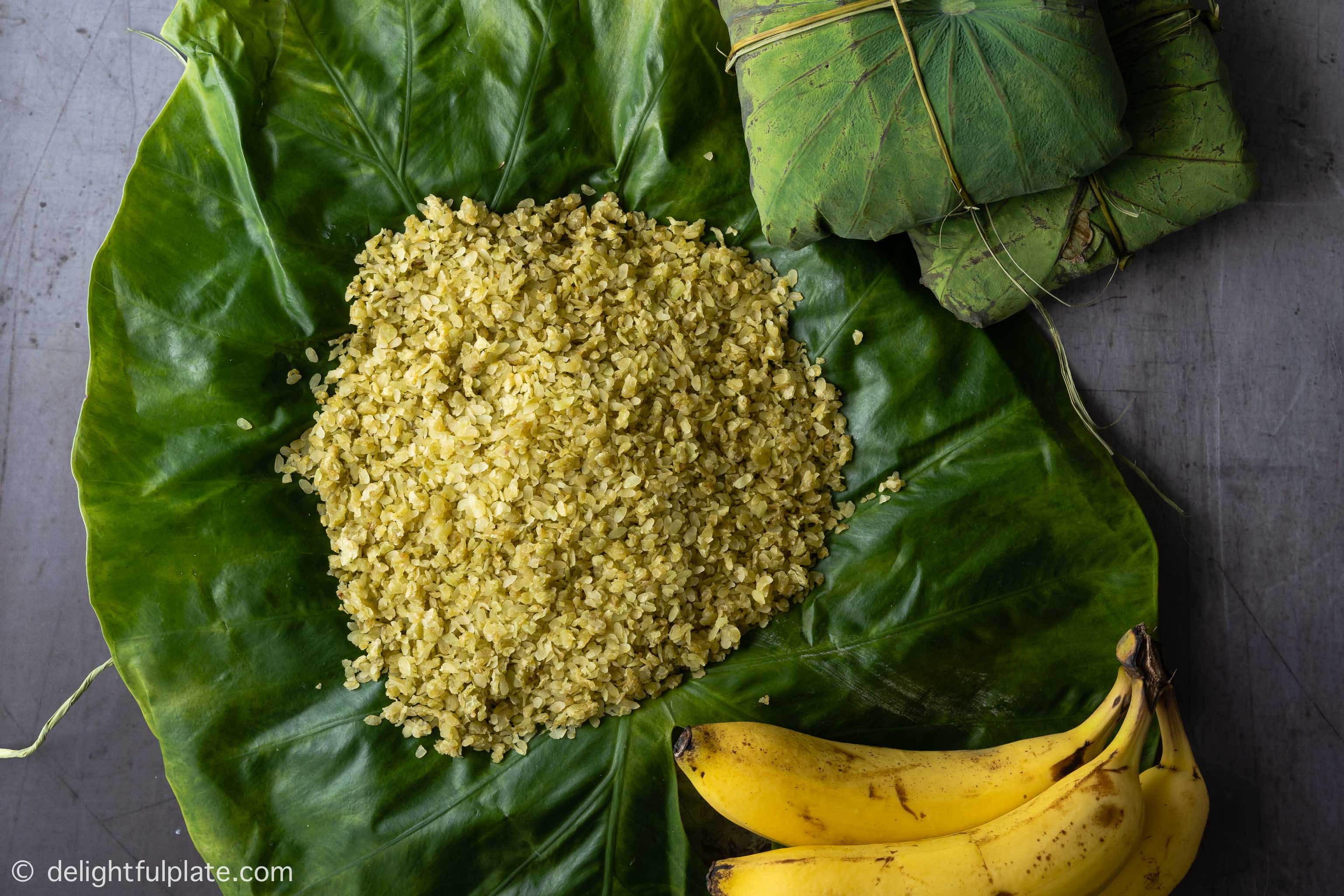 a small pile of Vietnamese green young rice, served with ripe bananas