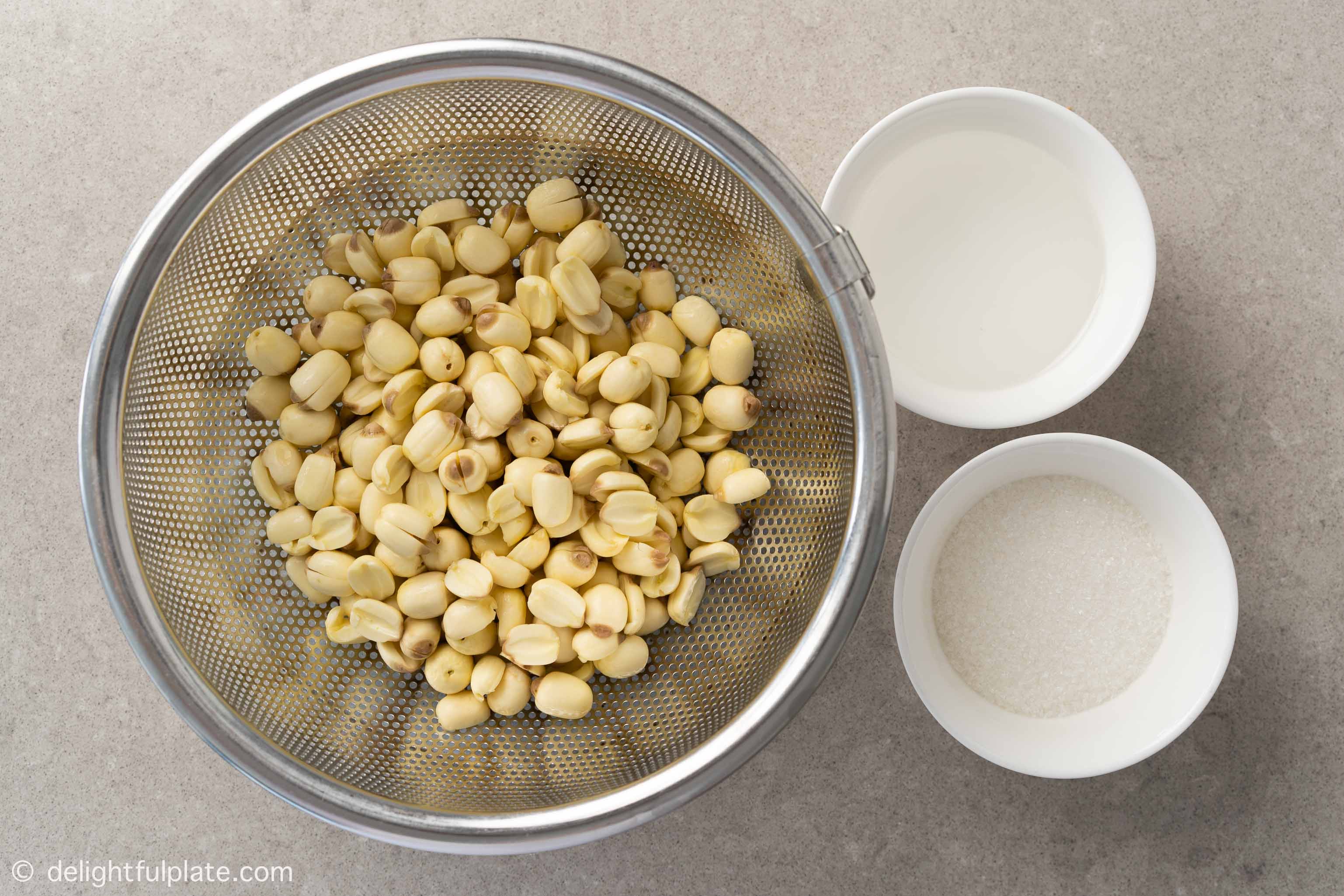 bowls containing ingredients to make the paste: lotus seeds, oil and sugar