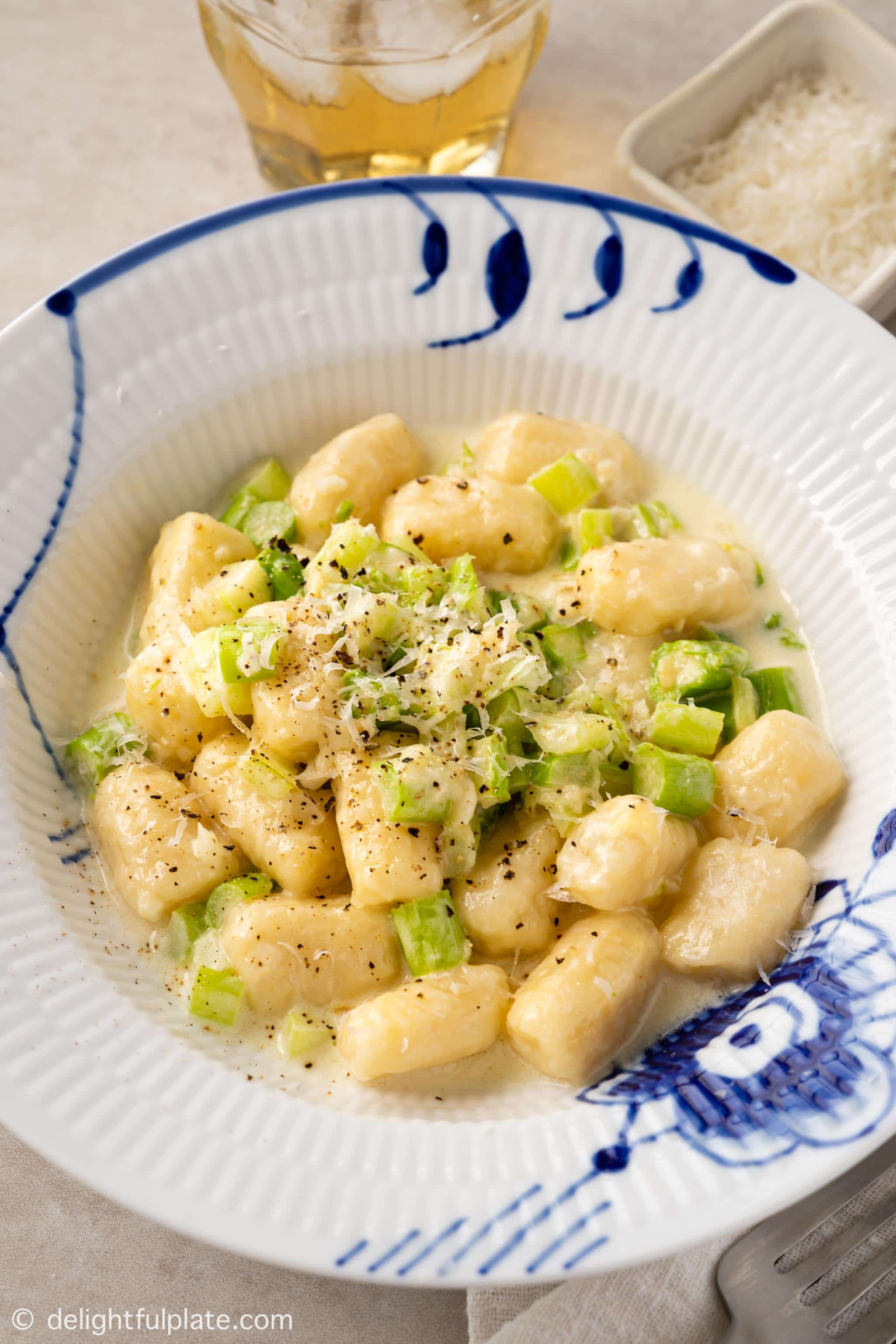 a plate of gnocchi with asparagus and cream sauce
