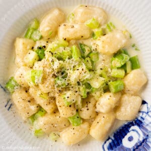 a plate of gnocchi and asparagus in cream sauce