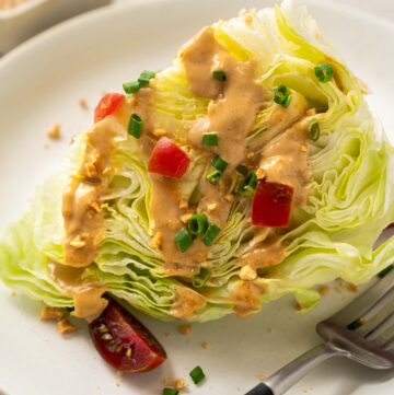 a wedge of iceberg lettuce served with peanut dressing