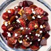 a plate of roasted beet salad with goat cheese, walnut and cherry tomato