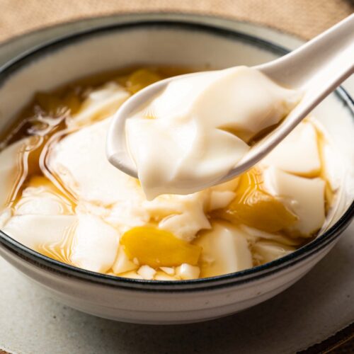 a bowl of tofu pudding with ginger syrup