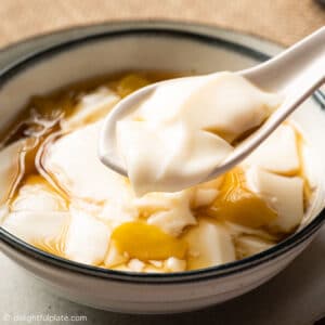 a bowl of soybean pudding with ginger syrup
