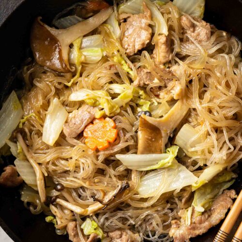 braised glass noodles with pork and napa cabbage in a wok