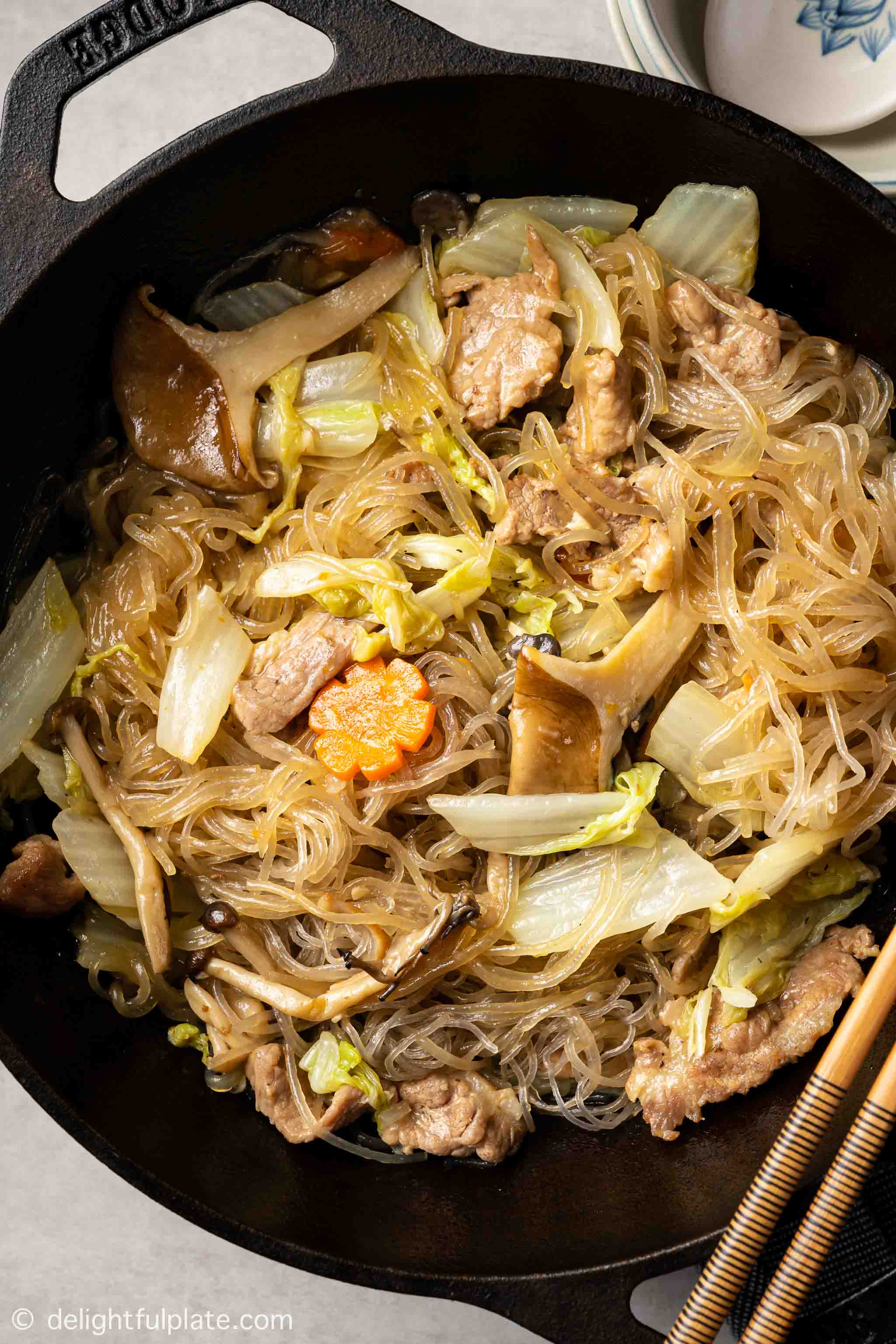 braised glass noodles with pork and napa cabbage in a wok
