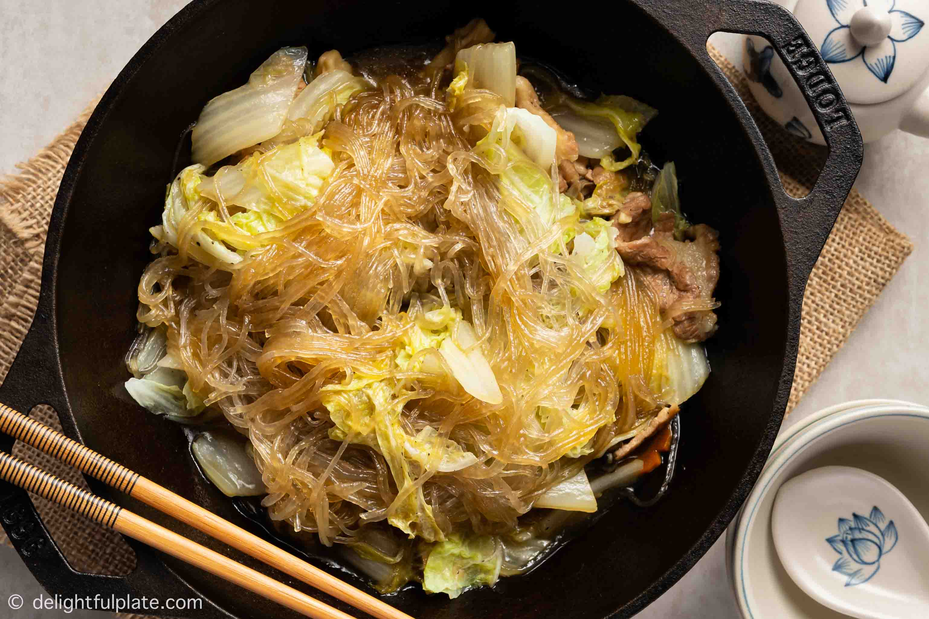 glass noodles with napa cabbage and pork in a wok