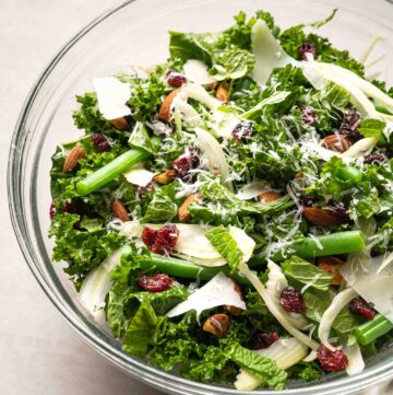 a bowl of kale salad with fennel, green bean, almond and cranberry