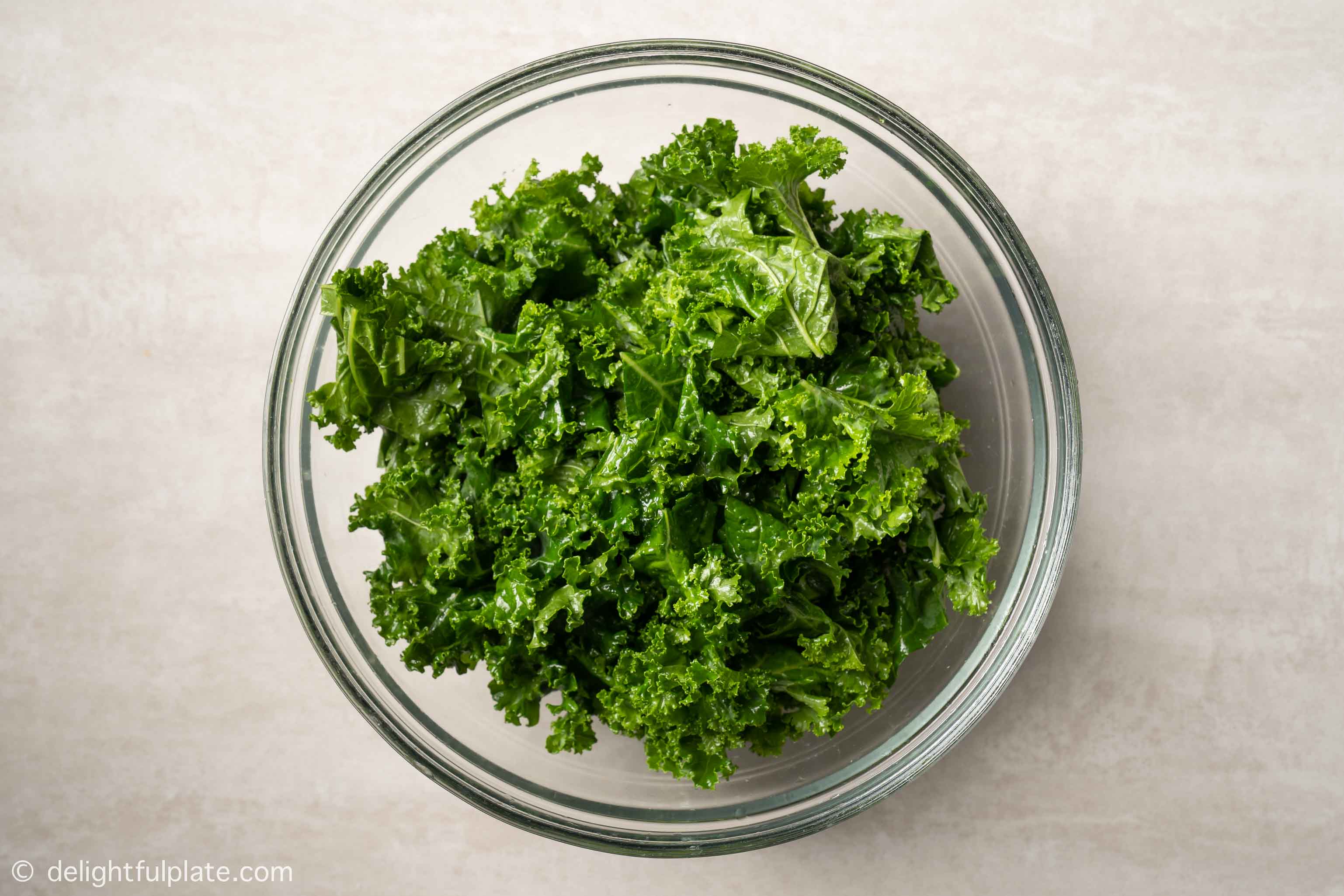 a bowl of kale massaged with oil and salt