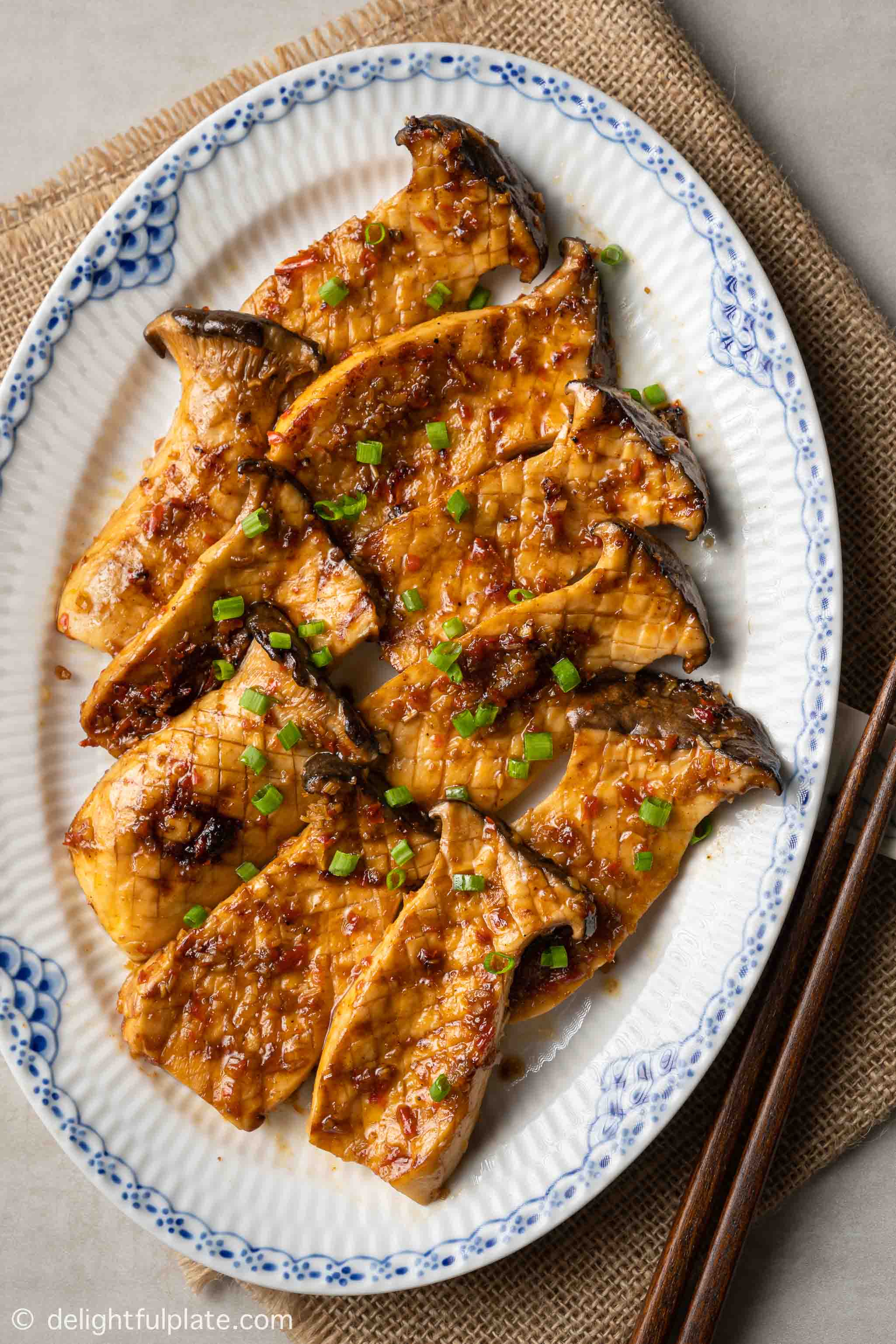 a plate of grilled king oyster mushrooms with sate sauce