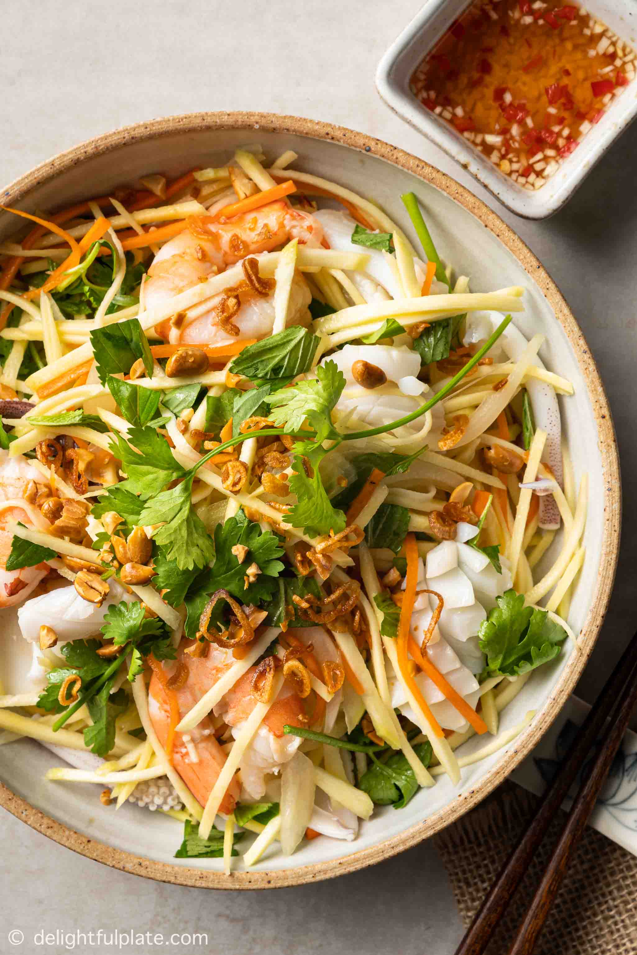 a plate of Vietnamese green mango salad with seafood.