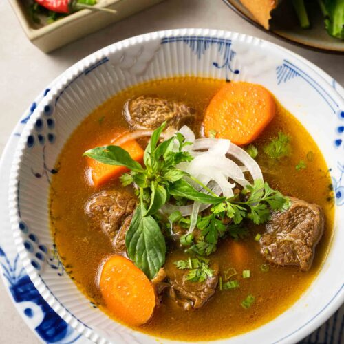a bowl of bo kho (Vietnamese beef stew) served with banh mi