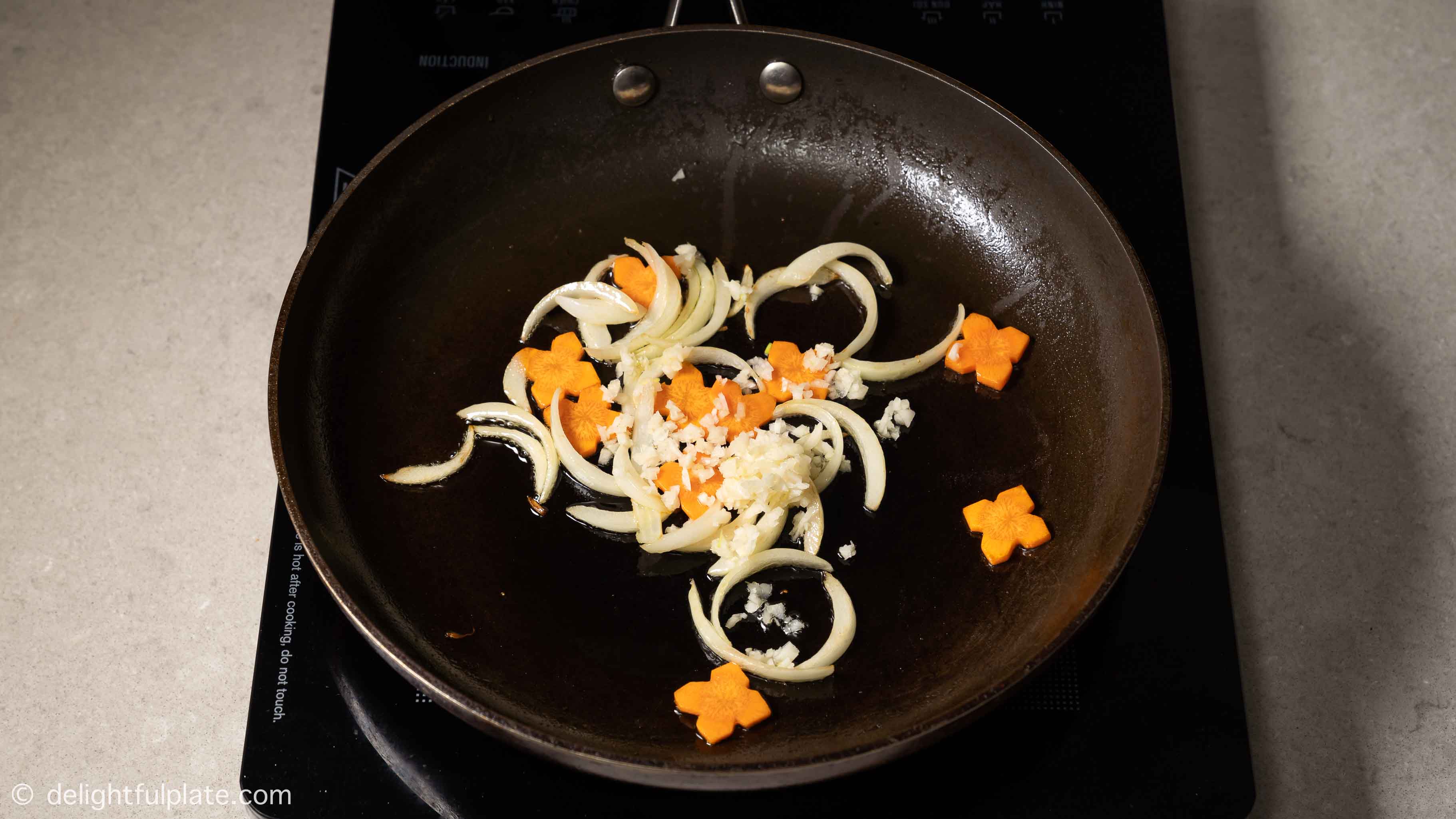 saute aromatics and carrots in a pan