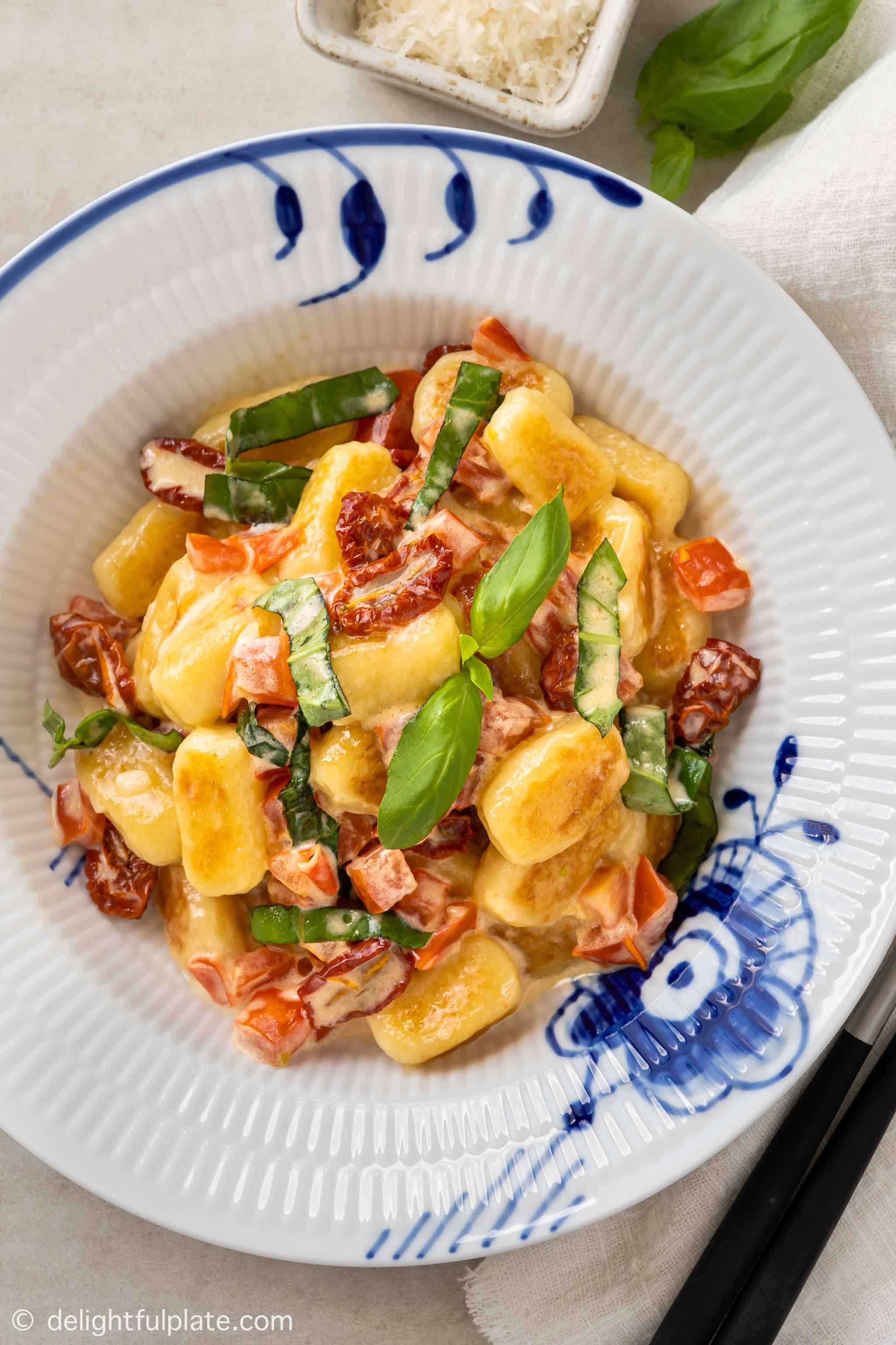 a plate of sun dried tomato gnocchi in cream sauce