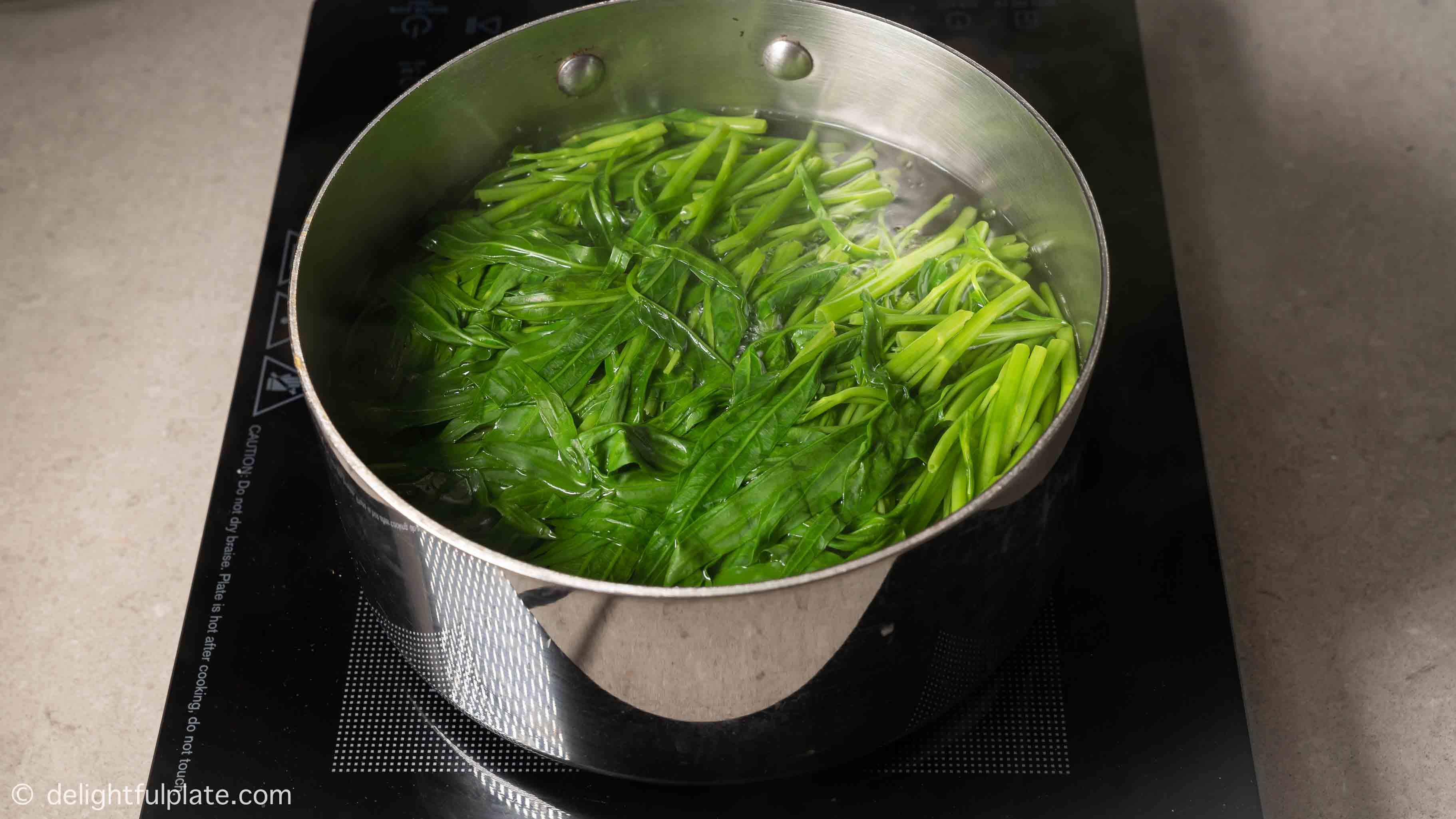 blanching water spinach in a large pot