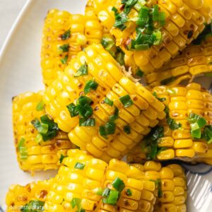 a plate of grilled corn with scallion oil