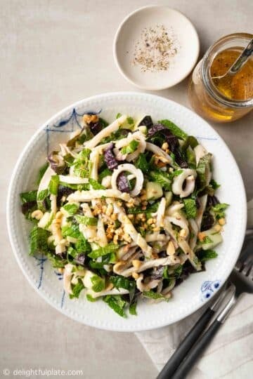 a plate of grilled squid salad with dressing on the side
