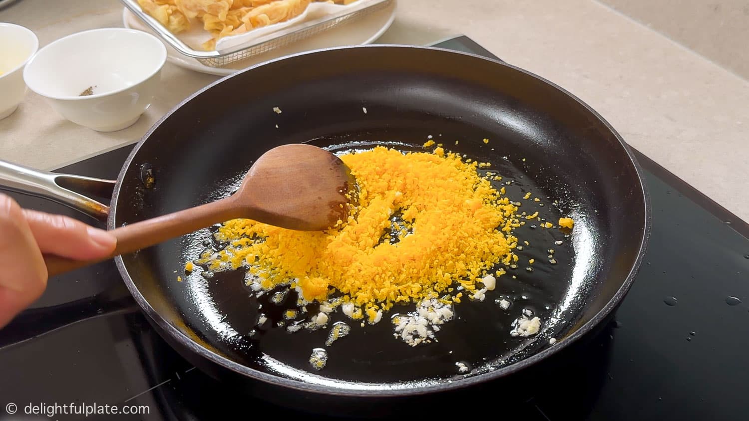 stirring salted egg yolk with garlic