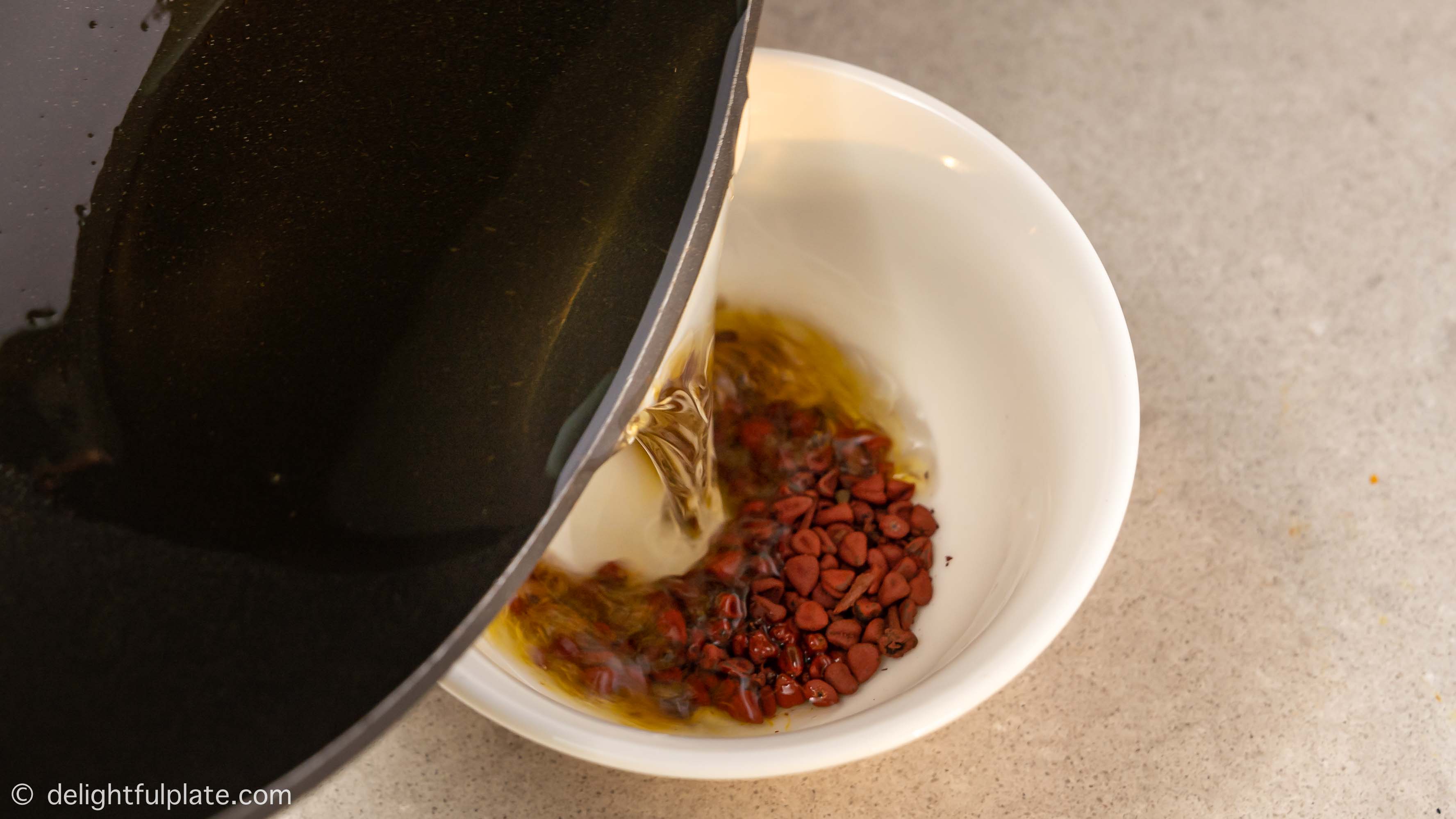 pour oil over annatto seeds
