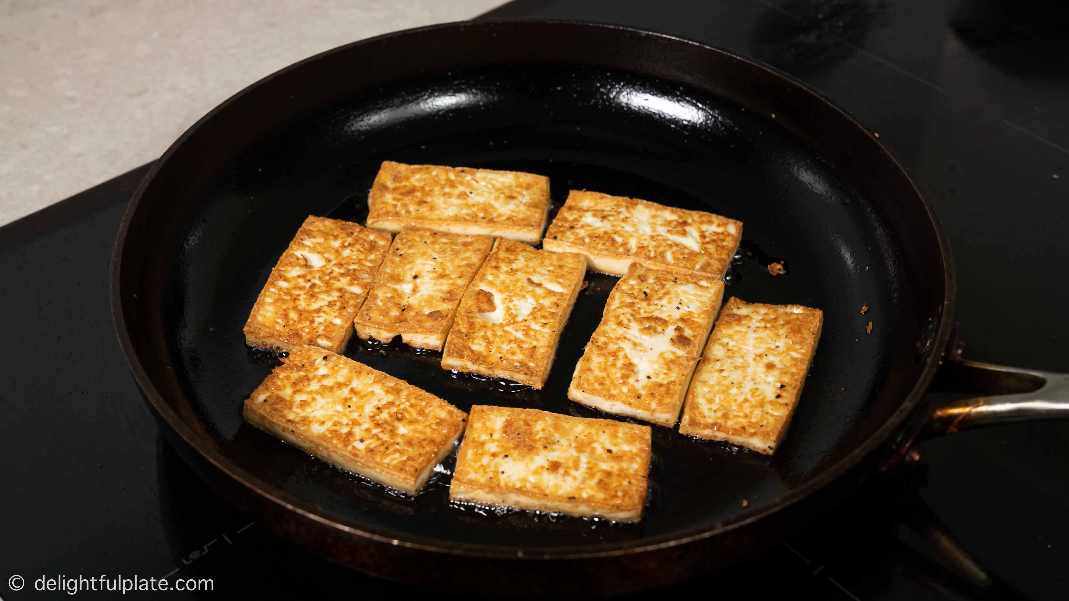 frying tofu slices in a pan