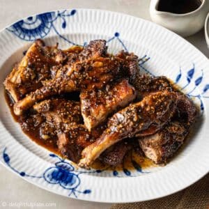 a plate of chopped roasted duck legs with black pepper sauce